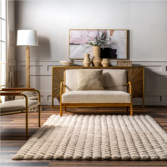 Modern living room with a beige sofa, rug, and decorative items.