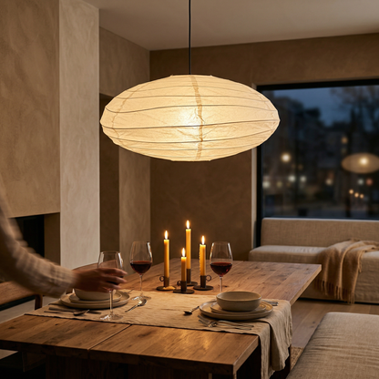 Japanese style round paper lantern creating a warm, cozy dining room atmosphere at night over a wooden table.
