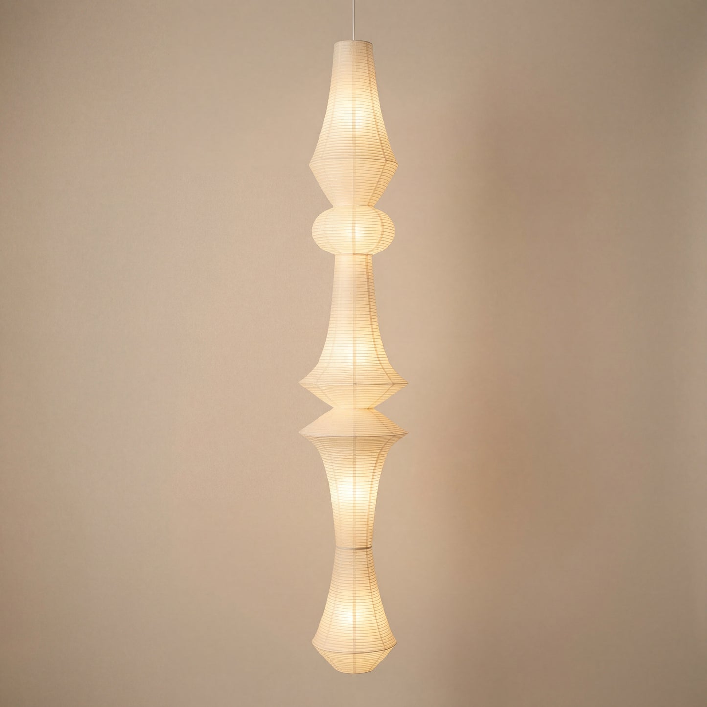 Handcrafted rice paper pendant light with a tall sculptural design, ideal for Japandi or mid-century modern spaces.