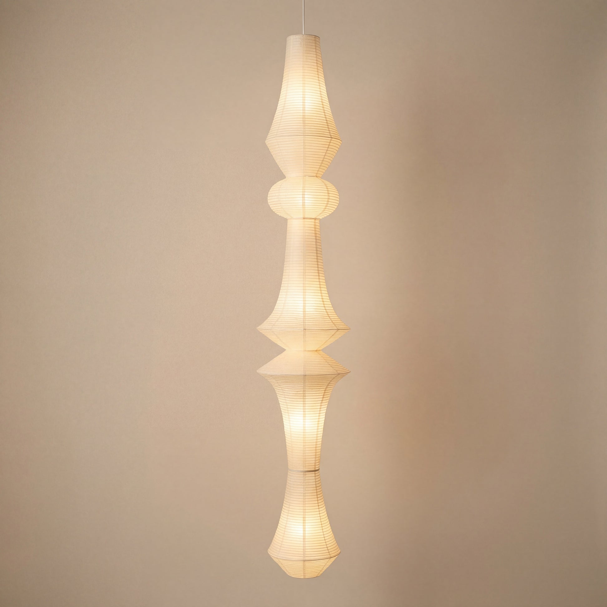 Handcrafted rice paper pendant light with a tall sculptural design, ideal for Japandi or mid-century modern spaces.