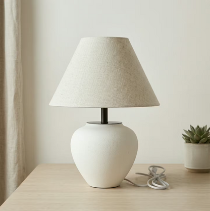 White ceramic table lamp with rounded base and warm linen drum shade for Japandi and Scandinavian decor