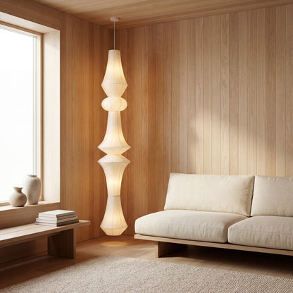 A Japandi living room with floor-to-ceiling windows featuring a tall sculptural washi paper floor lamp as a statement piece with soft ambient glow.