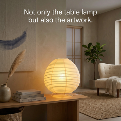 Warm spherical Japandi table lamp on a styled table with books, a terracotta vase, and abstract wall art.