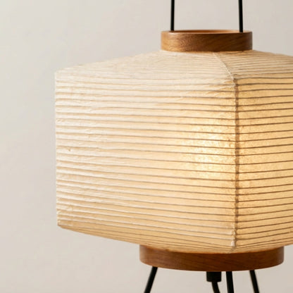 A warm, soft-glowing Japanese paper lantern placed on a bedside nightstand, creating a cozy and minimalist atmosphere.