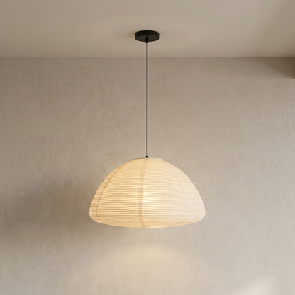 Japanese-inspired dome-shaped rice paper pendant light with metal ribbing, illuminated to show a soft, warm glow.