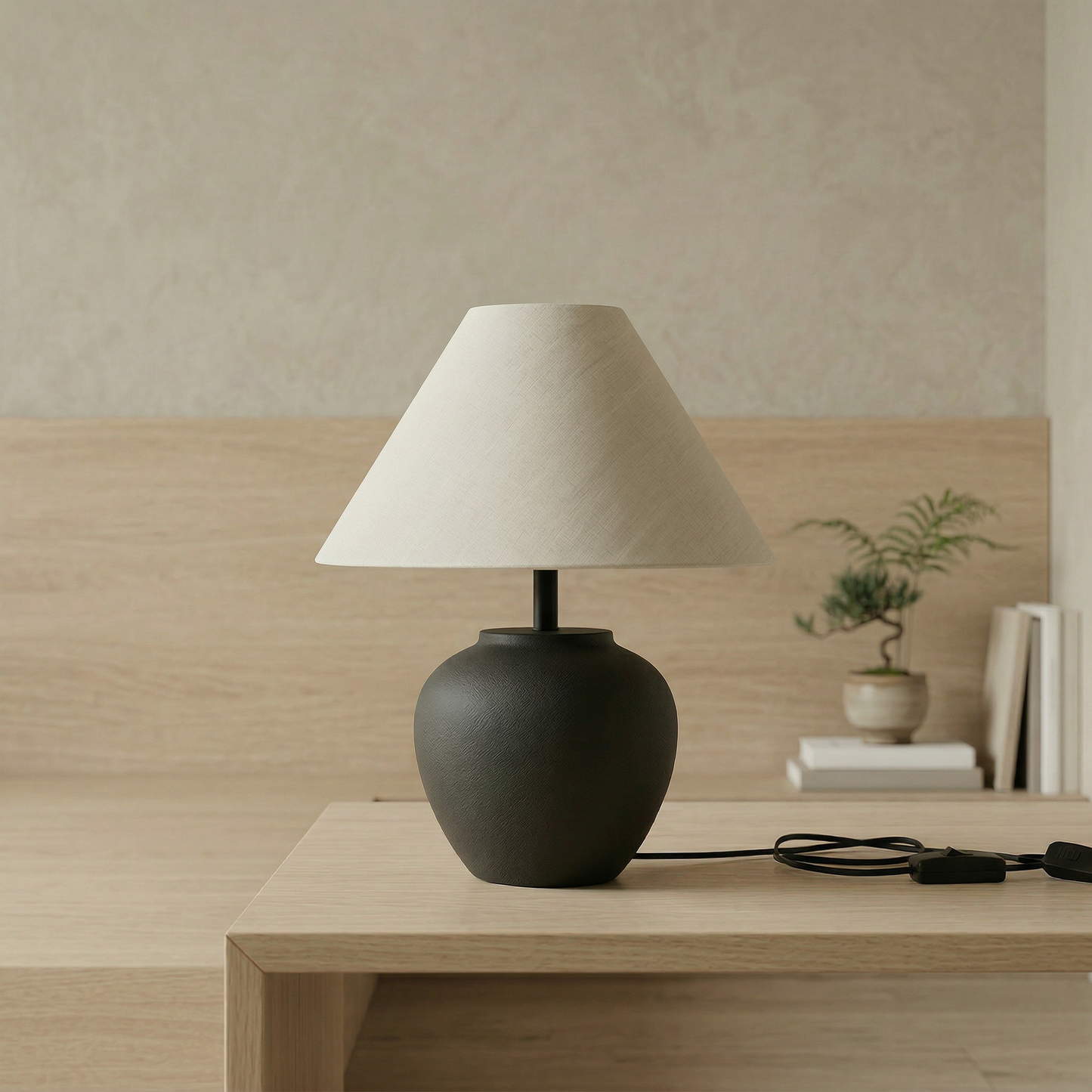 Minimalist charcoal ceramic table lamp with rounded ceramic base and warm linen shade for Japandi and Scandinavian interiors