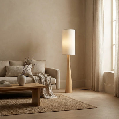 Modern minimalist living room decor with a tall wooden floor lamp, creating a soft, warm, and inviting atmosphere in a neutral-toned home.